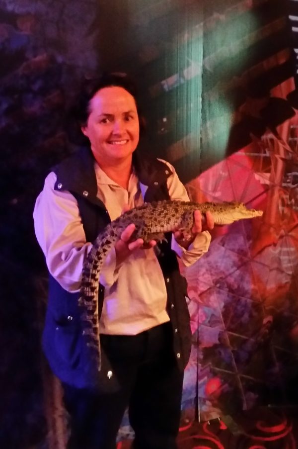 woman holding baby crocodile