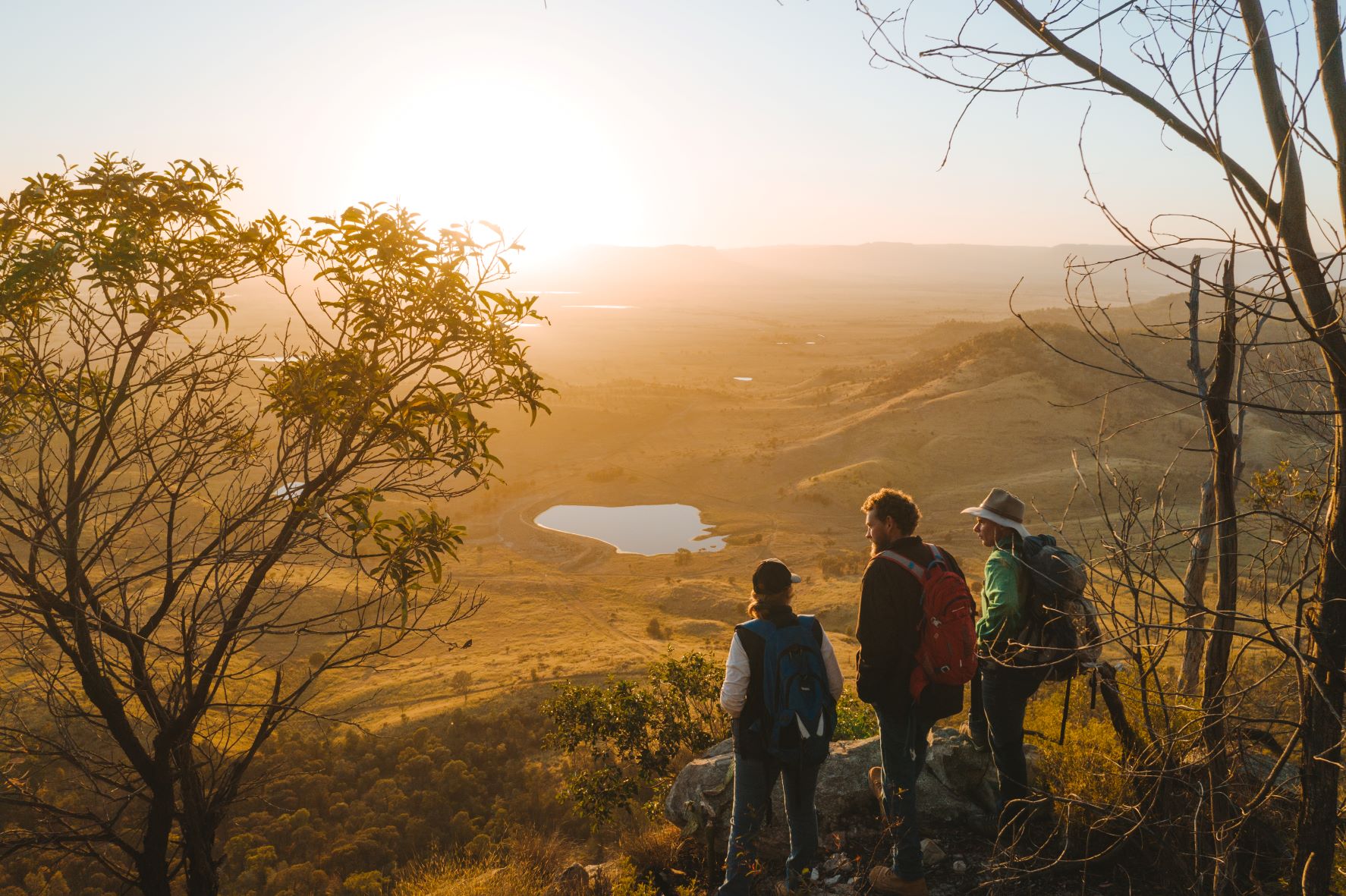 Three people overlooking Arcadia Valley vista at sunset