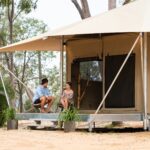 Wallaroo Outback Retreat glamping tent exterior. Two guests sitting on patio in the bushland setting