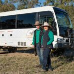 4WD vehicle with two people standing nest to the drivers side