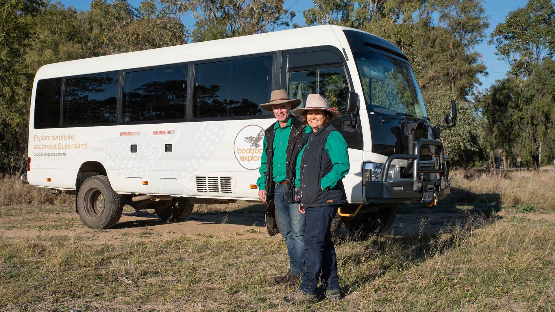 4WD vehicle with two people standing nest to the drivers side