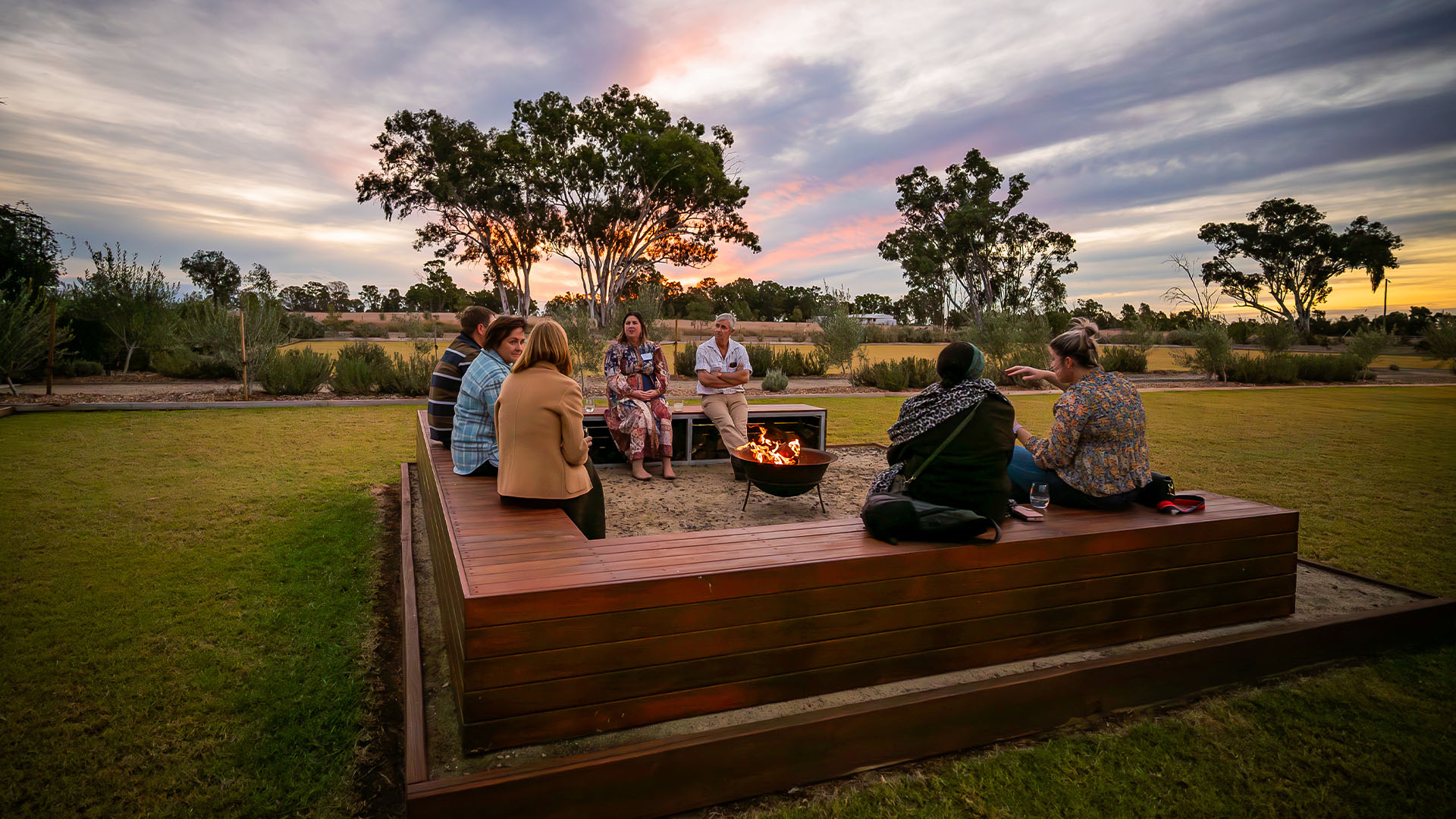 A group of people sitting around a firepit