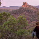A guest sitting don, looking over a valley filled with trees