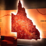 Two people looking at a backlit map of Queensland