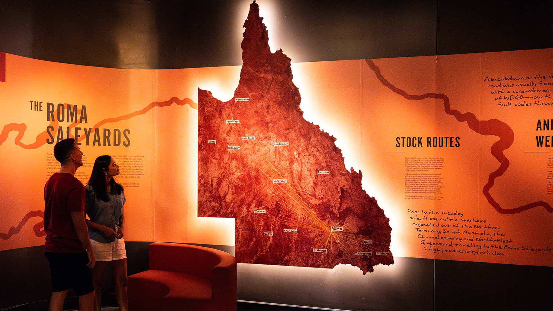 Two people looking at a backlit map of Queensland