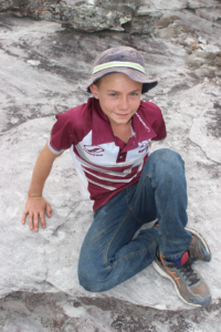 boy out hiking sitting on rock