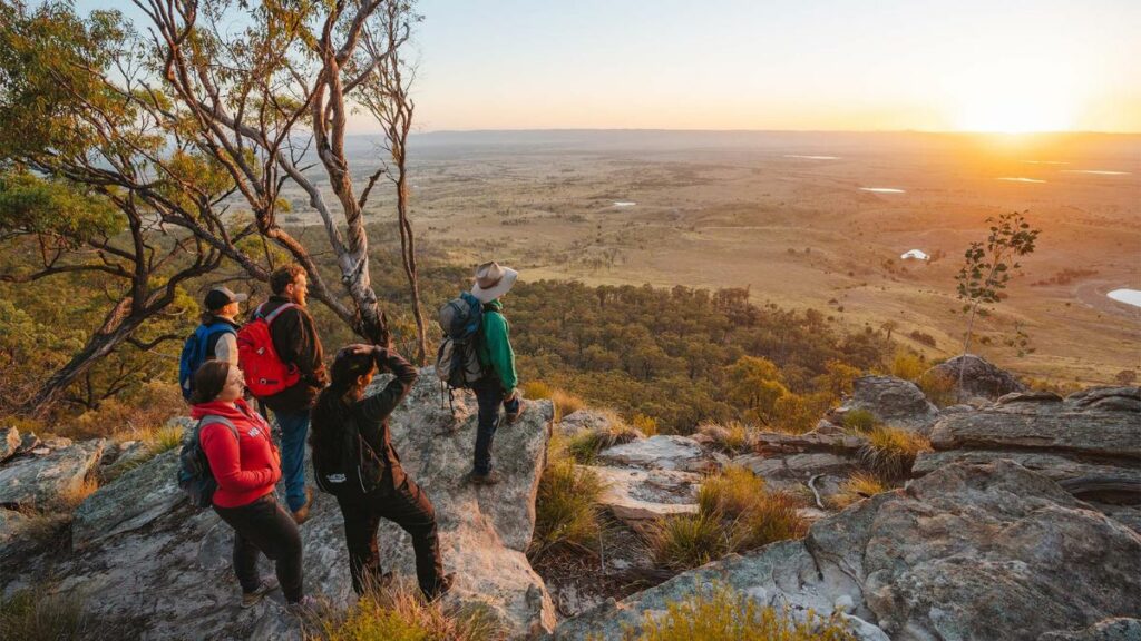 a group of people overlooking arcadia valley at sunset