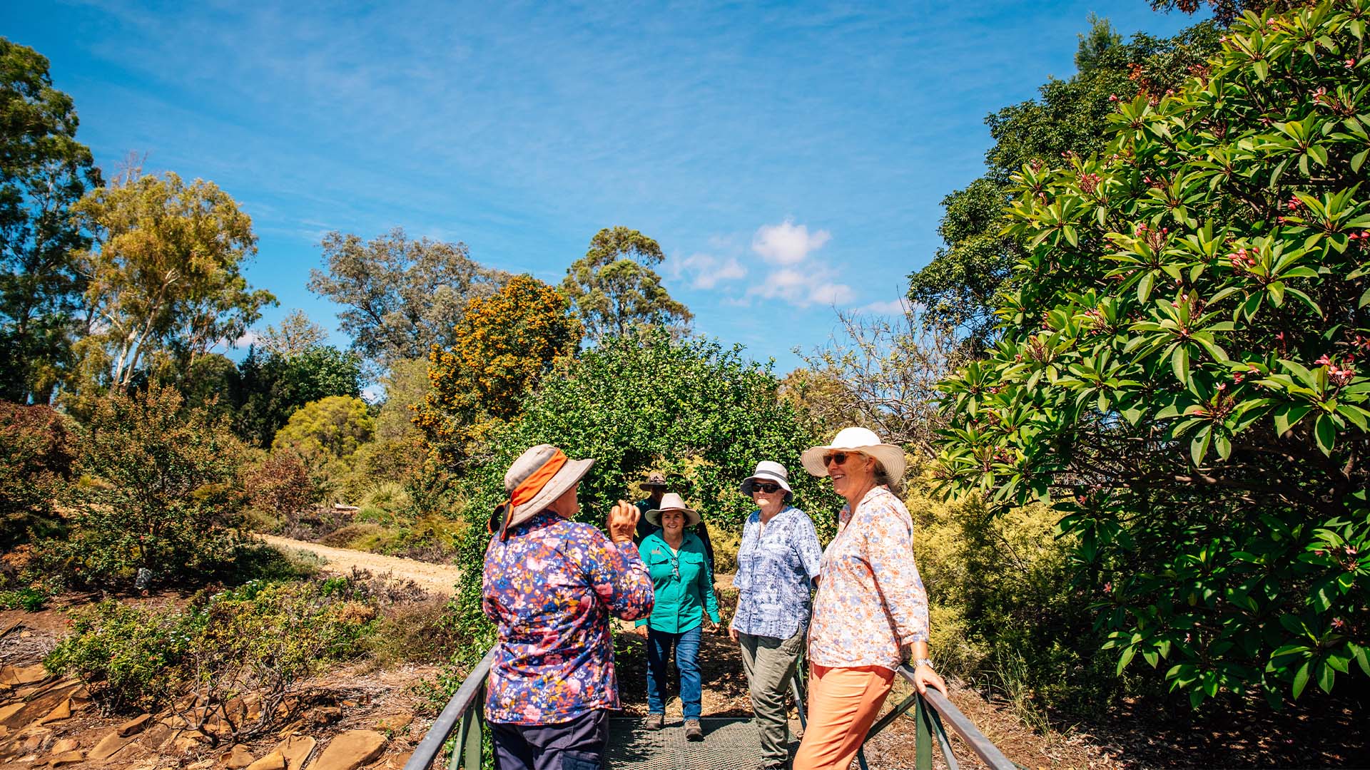 A group of people stopped on a bridge chatting