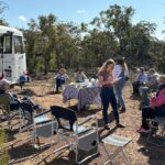 A group of guests enjoying morning tea in a bush setting
