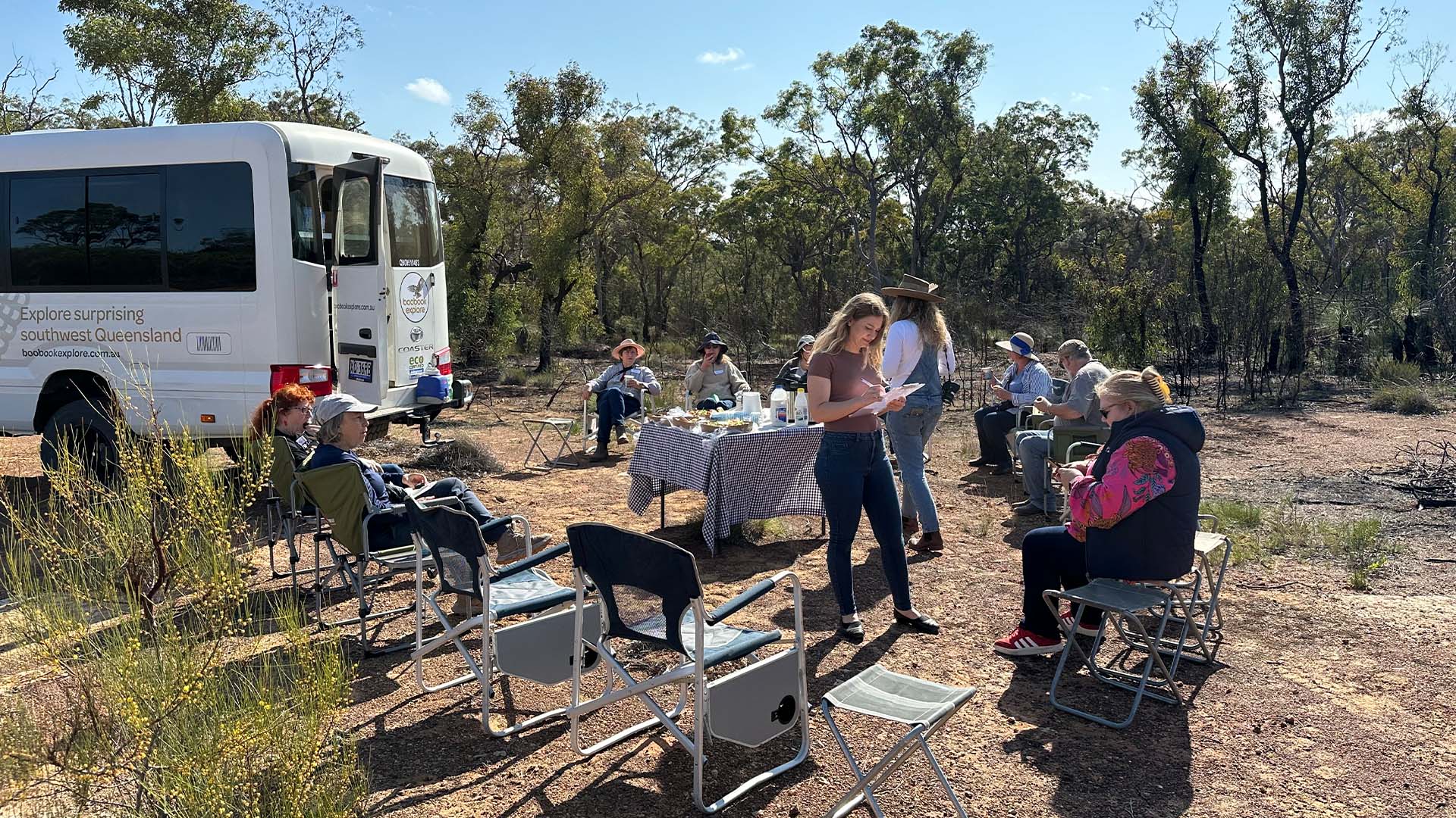 A group of guests enjoying morning tea in a bush setting