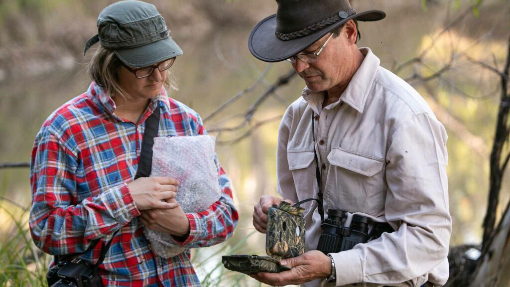 two people looking at research from the river