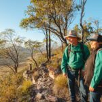 two tour guides looking out to the valley below