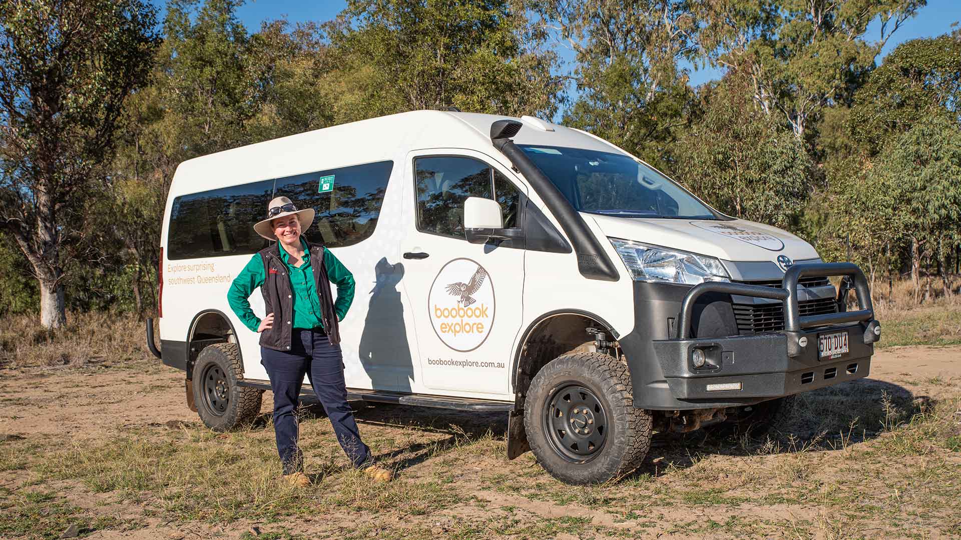 Rose Aisthorpe posing besides a white 4WD tour bus