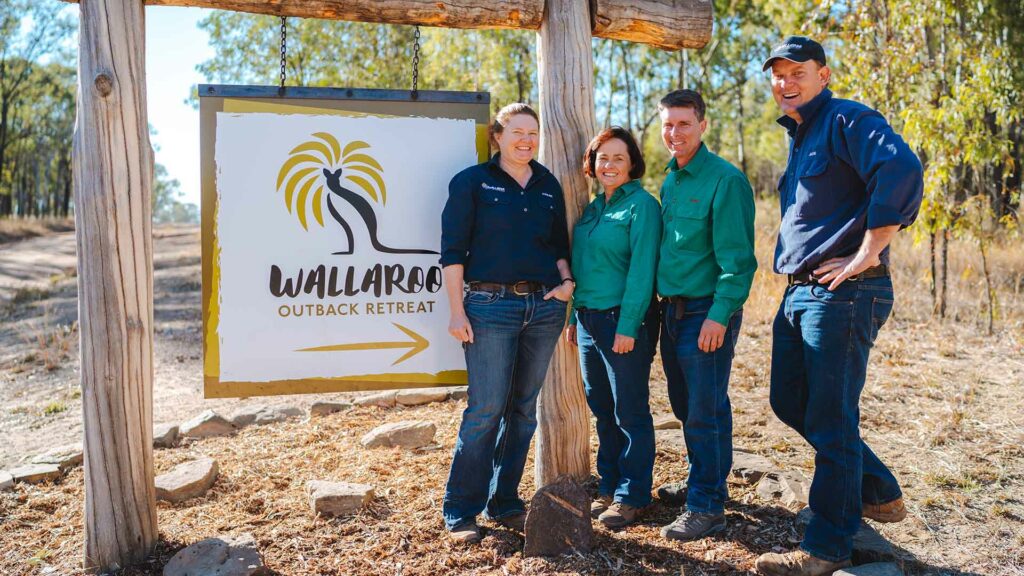 Four people standing next to Wallaroo Outback Retreat's entry sign